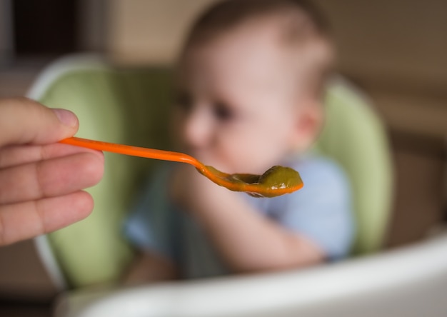 Photo baby boy eating in the kitchen