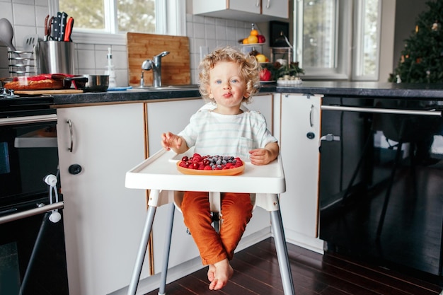 baby boy eating ripe red fruits at home supplementary healthy finger food for toddler kids