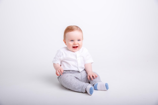 A baby boy is sitting on a white background isolated