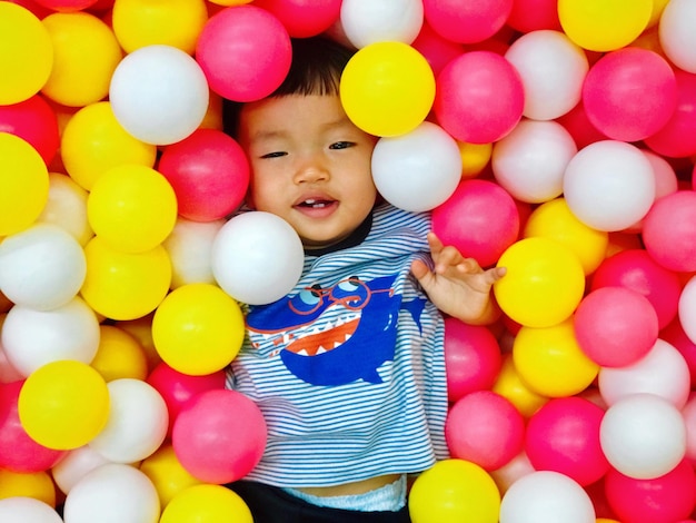 Baby boy lying in ball pool