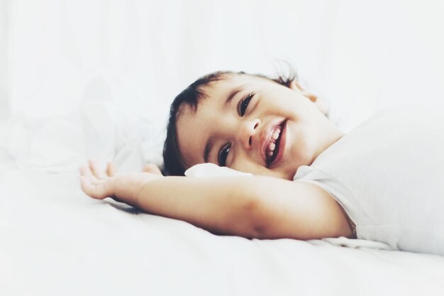 Photo baby boy lying on bed at home