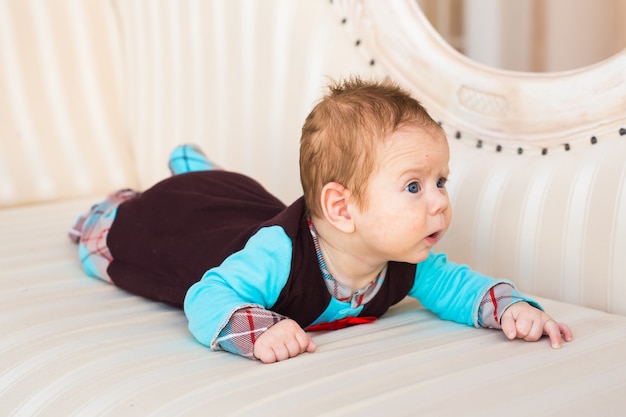 Baby boy lying on a sofa in sunny room