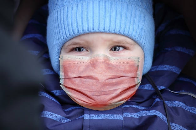 Foto bambino in una maschera medica sul viso