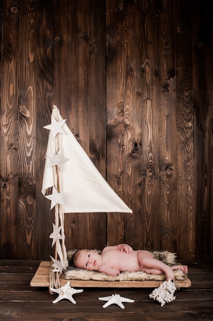 baby boy, photo studio on a wooden background