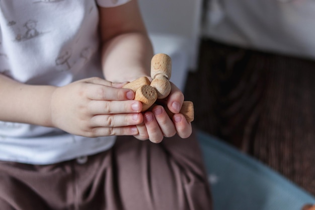 Мальчик играет с деревянными игрушками, кирпичами и журавлем в детской комнате в пастельно-мятных и коричневых тонах