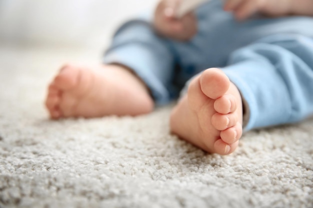 모직 카펫에 아기의 발을 닫습니다.