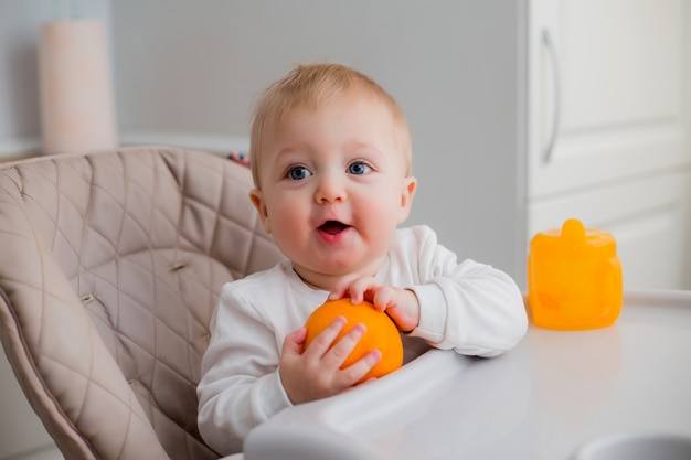 baby boy sitting in a child's chair in the kitchen