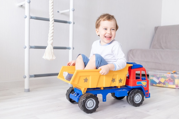 Baby boy sitting or riding in a typewriter at home the concept of a child's game