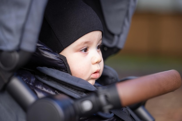 Photo baby boy sitting in a stroller outside in a park burnaby vancouver bc canada