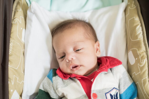 Baby boy sleeping in baby stroller