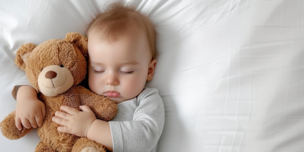 Baby boy sleeping on white mattress while hugging teddy bear