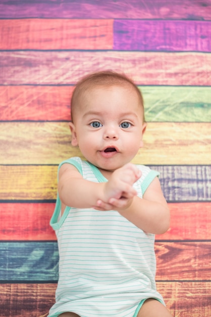 Baby boy in studio with colorful wooden background