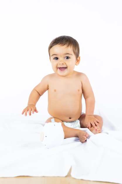 Baby boy in a studio with a white background, newborn caucasian eight months old smiling, vertical photo