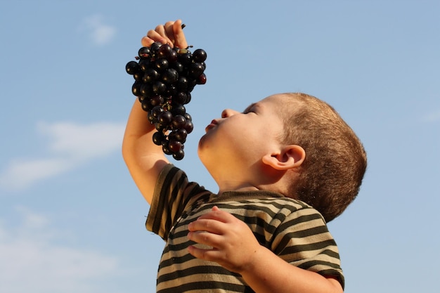 Baby boy with an grape