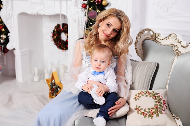 Baby boy with his mother in elegant clothes sitting