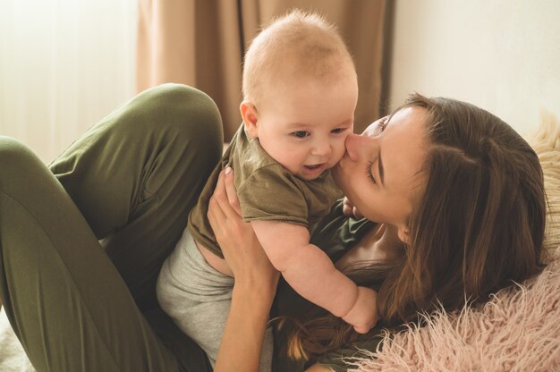 Photo baby boy with mother on the bed