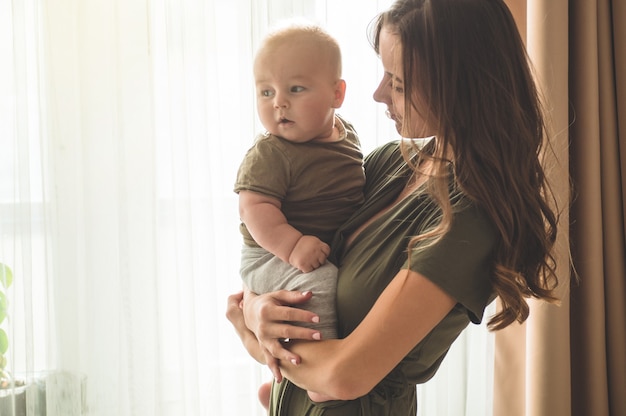 Baby boy with mother near the window