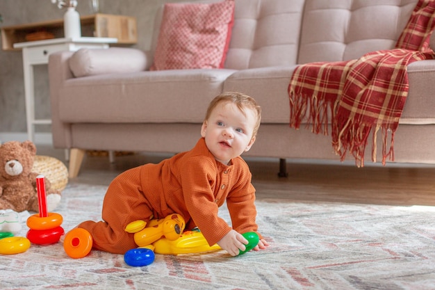 Baby boy with toys crawling on the floor at home