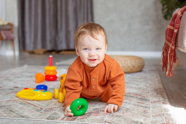 Baby boy with toys crawling on the floor at home