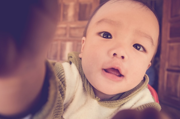 Baby boy on wooden background, vintage stley