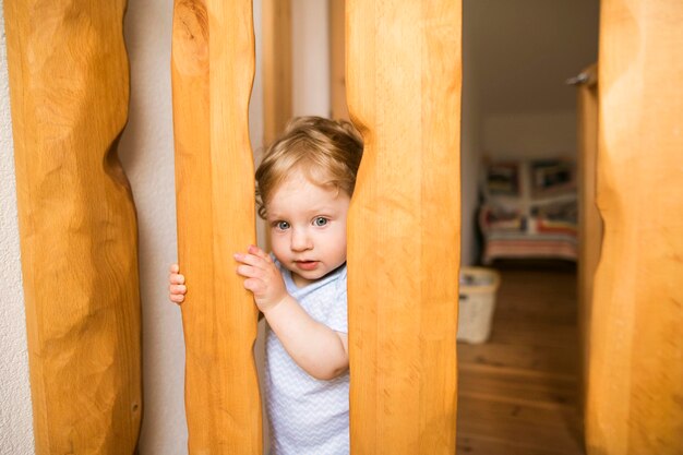 Baby boy behind wooden barrier