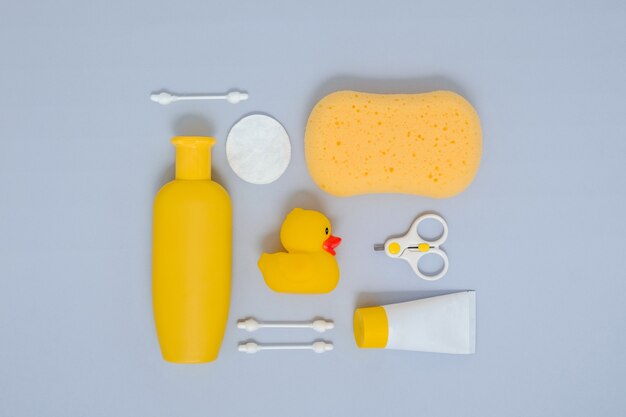 Baby care concept Flat lay composition of bathing accessories for newborn on grey background