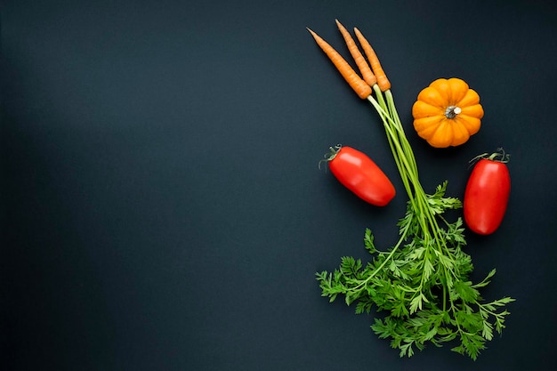 Foto carotine piatte con foglie verdi pomodori e zucca