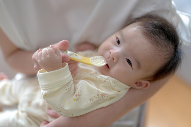 スプーンを口に運ぶ赤ちゃん