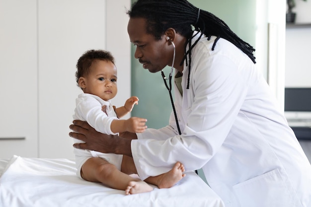 Foto baby check up black pediatra medico esaminando il piccolo neonato in clinica