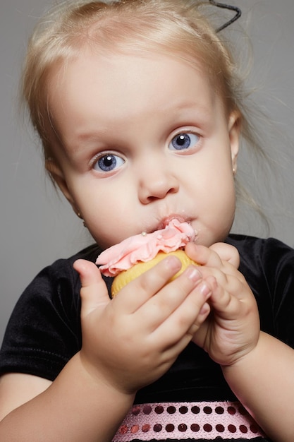 Baby child is enjoying a cake