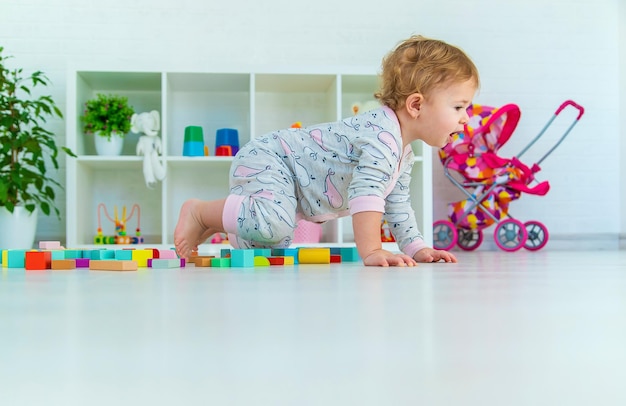 A baby child plays with toys in the playroom Selective focus Kid