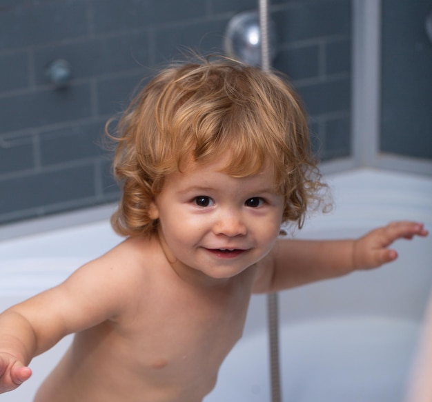 Baby child washing in a bathroom in foam