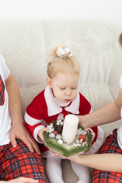 Baby child with hearing aid and cochlear implant having fun with parents in christmas room deaf div