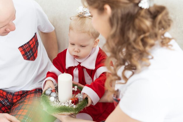 Baby child with hearing aid and cochlear implant having fun with parents in christmas room deaf div