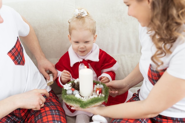 Baby child with hearing aid and cochlear implant having fun with parents in christmas room Deaf diversity and health concept