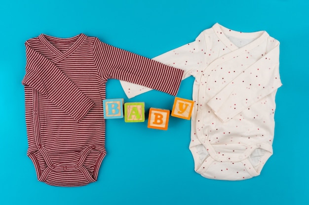 Baby clothes on blue background top view