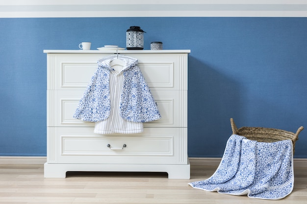 Baby clothes hanging on rope on grey background