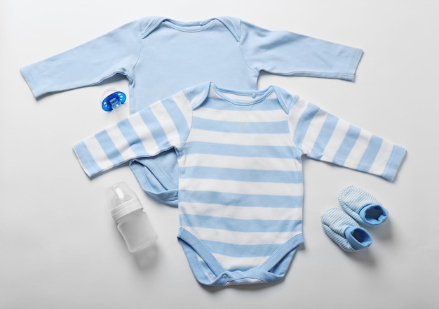 Photo baby clothes and necessities on light background