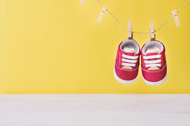 Concetto di bambino con le scarpe sul clothesline