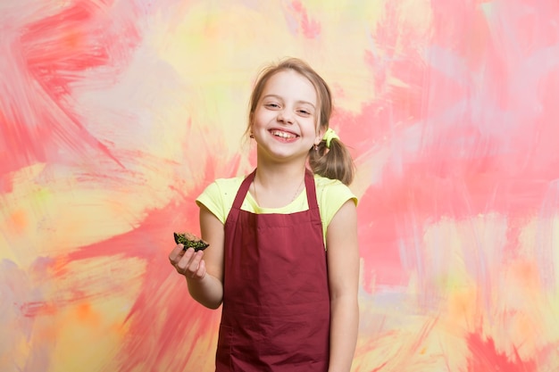 Baby cook in red chef apron on colorful abstract wall