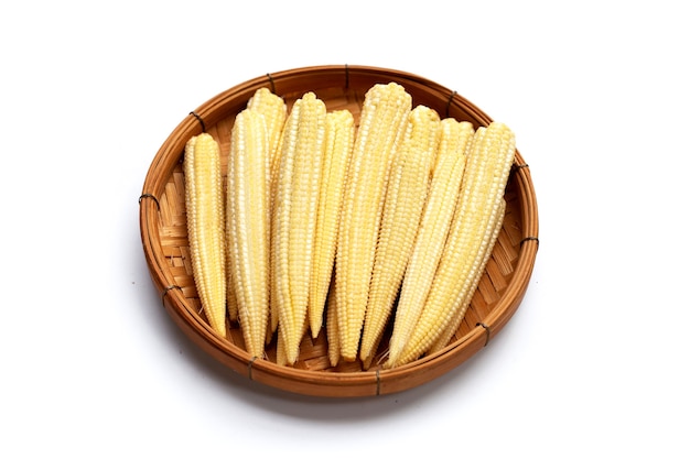 Baby corn in bamboo basket on white background