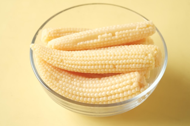 baby corn in a bowl on yellow background