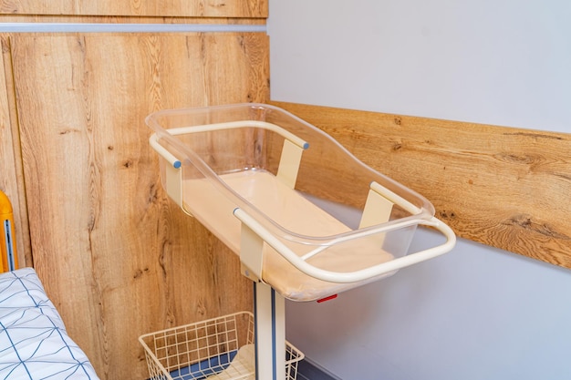 Baby cradle in the maternity hospital. Postpartum ward in the clinic. Empty bed for a newborn. Closeup.