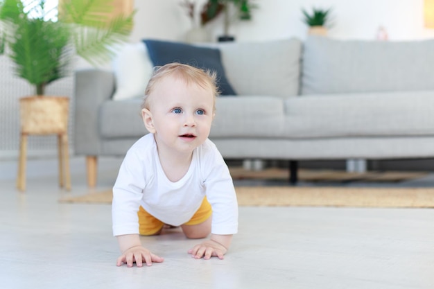 The baby crawls into the living room first steps