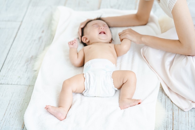 Bambino che piange in un pannolino sul pavimento