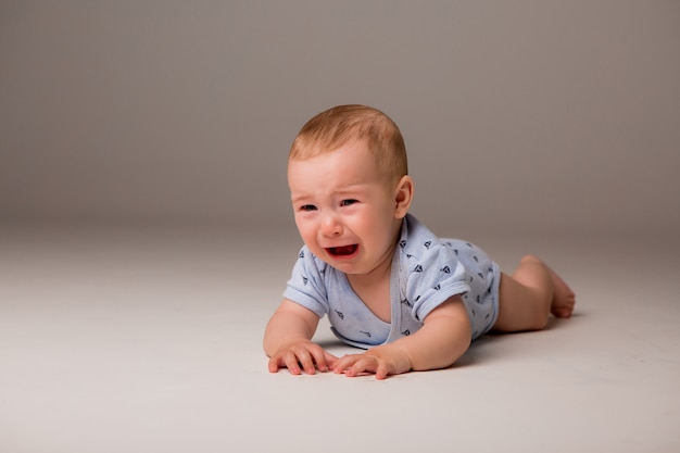 写真 泣いている赤ちゃんは明るい背景に分離します。