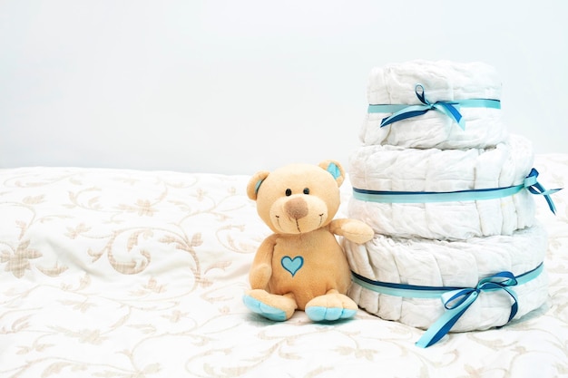 Baby diaper cake present with toy teddy bear for the expectant family set with blue colors for boy for baby shower with copy space