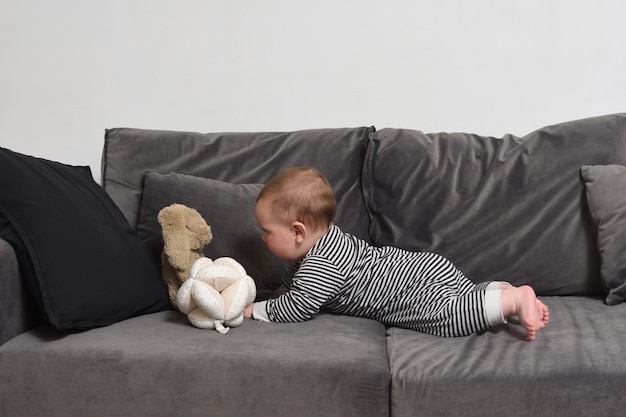 Baby die zijn speeltje wil pakken en liegt op zoek naar hem