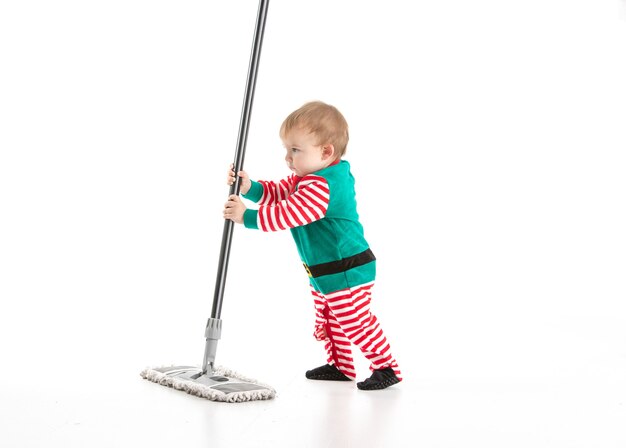 baby disguised as a elf playing with a mop