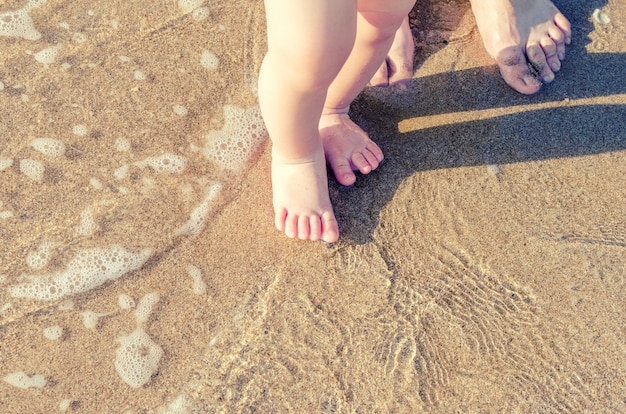 Baby doing his first steps on the beach